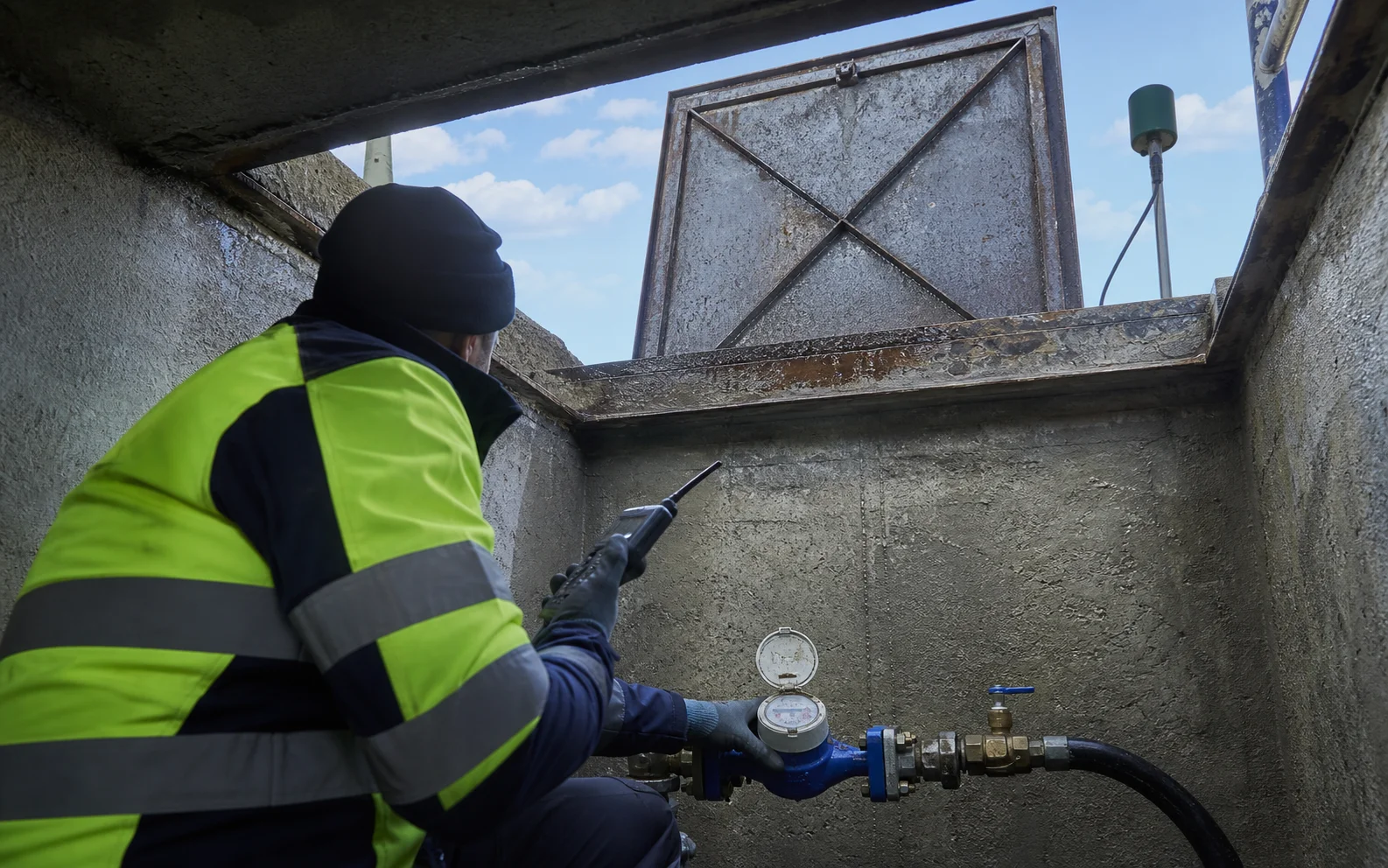 Técnico revisando un contador de agua conectado dentro de una arqueta