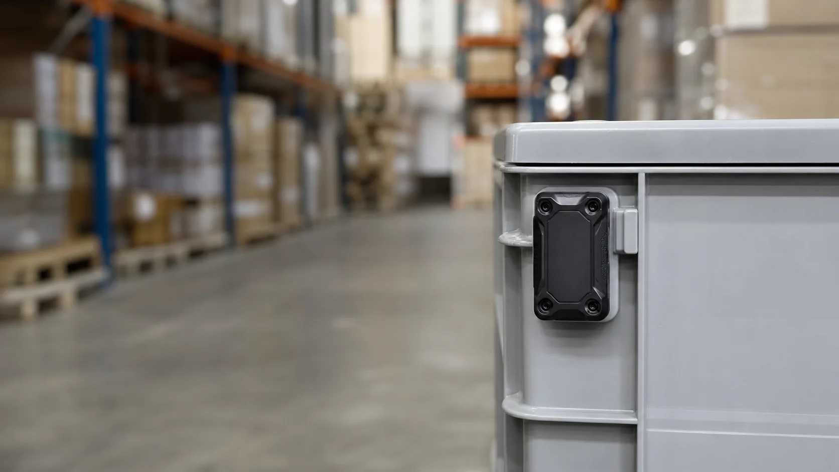 Localizador industrial fijado a una caja de transporte en un almacén